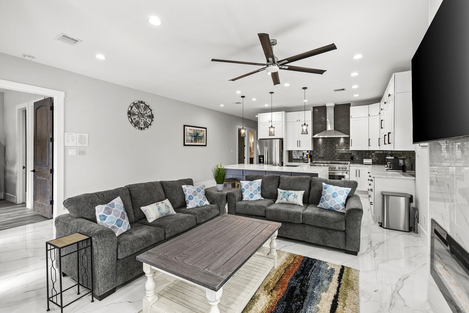 Open-concept living room and kitchen with sectional sofas